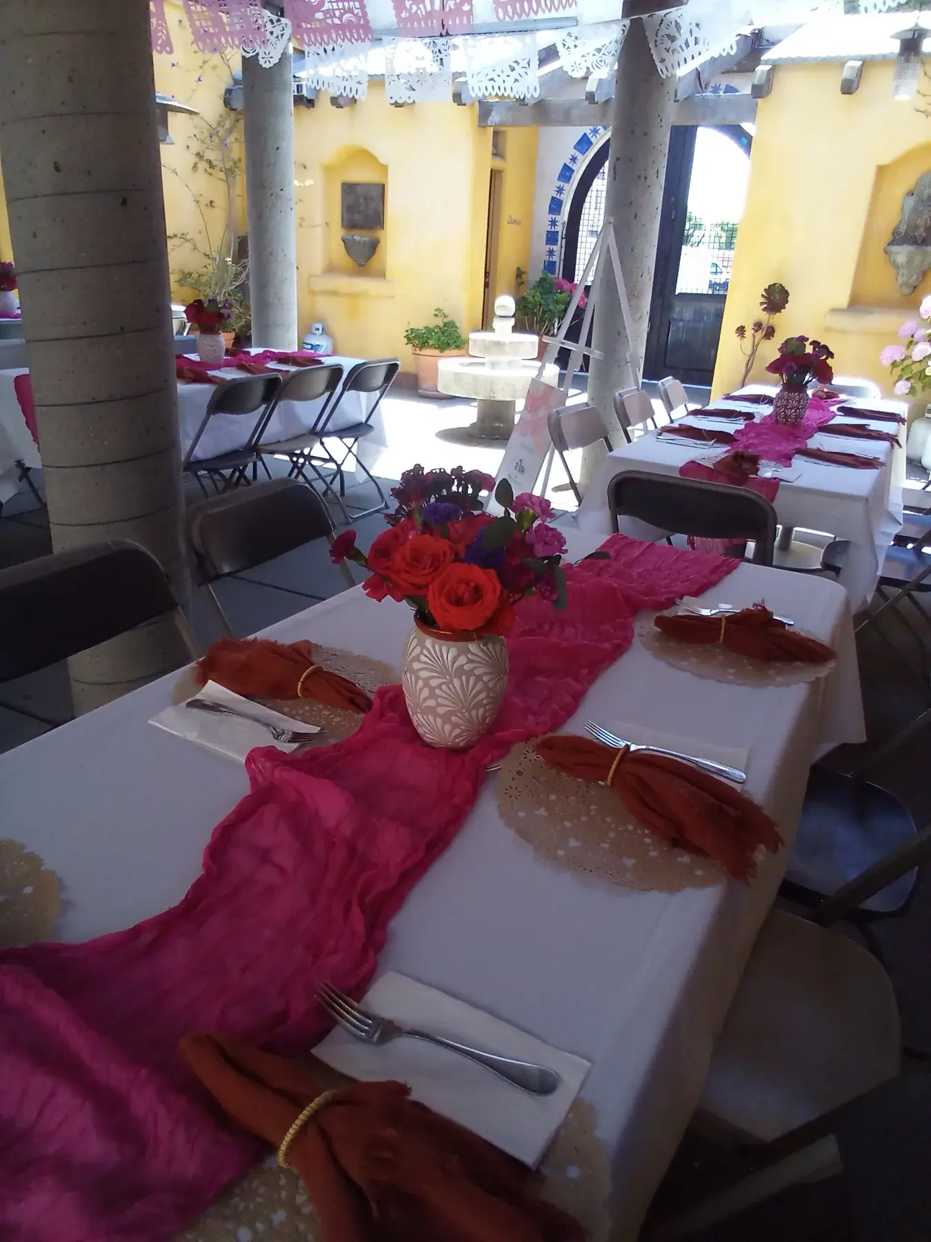 Colorful decorated tables arranged across the covered patio.